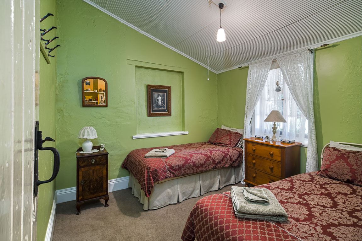 The second bedroom set up with single beds and a bedside table
