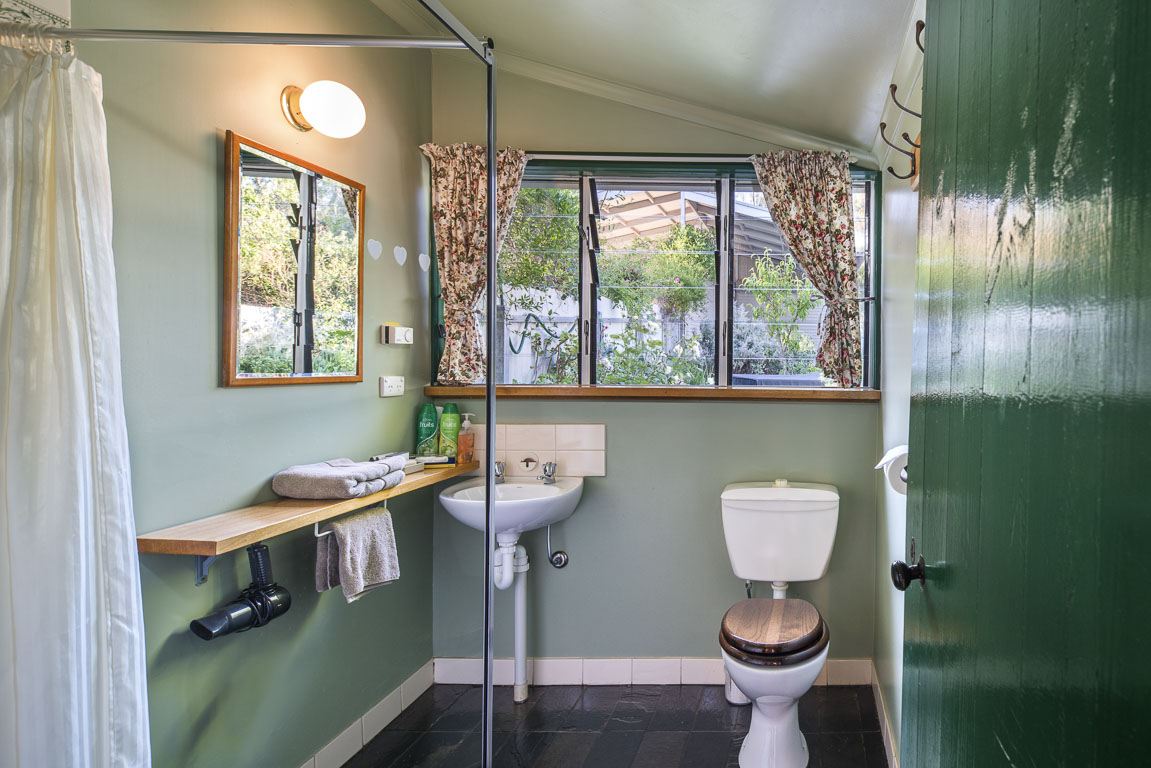 The bathroom with shower, basin and a window looking onto the garden