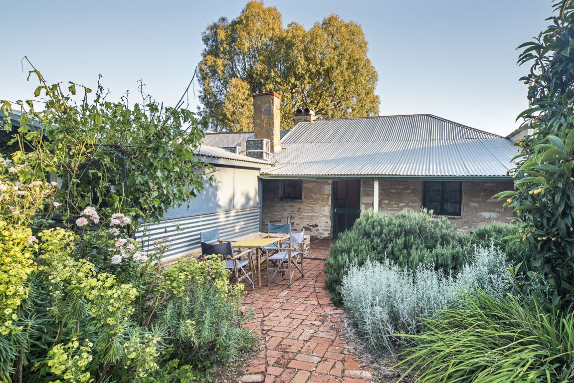 The private garden with outdoor seating, brick paths and lavender against the cottage wall