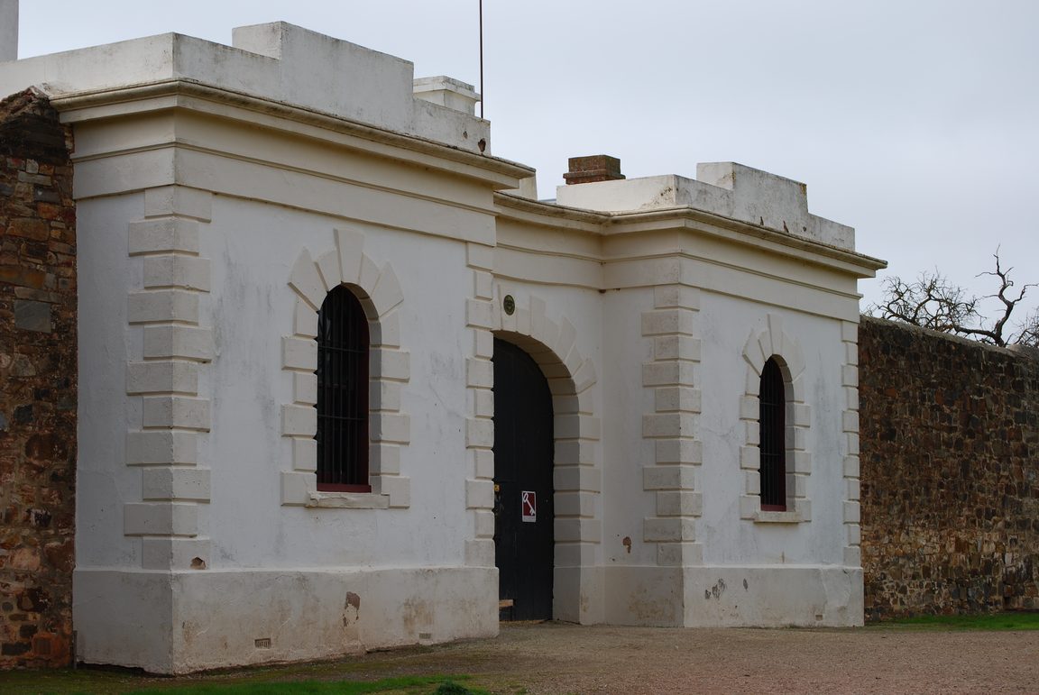The whitewashed gatehouse of Redruth Gaol with its studded black door