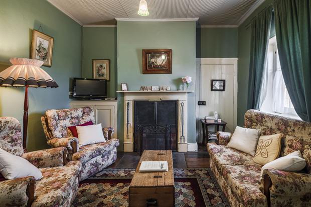 Cottage 8 — the cottage parlour with its open fireplace and armchairs