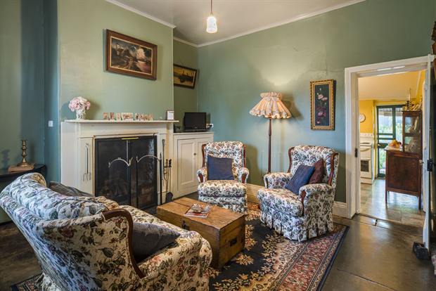 Cottage 10 — the cottage parlour with its open fireplace and armchairs