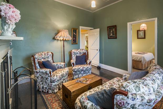 Cottage 10 — the cottage parlour with its open fireplace and armchairs
